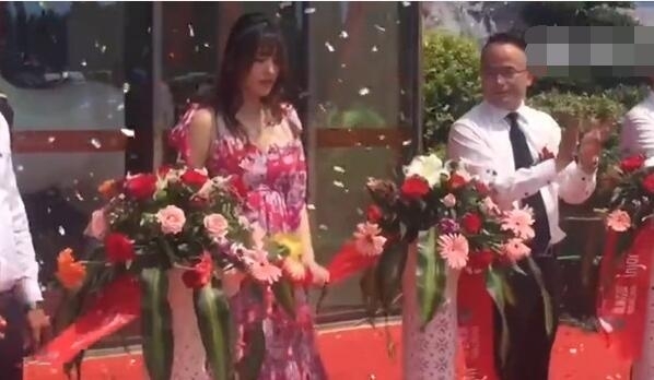 金莎剪彩时,手紧紧抓住红色的缎带